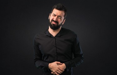 Obraz premium Handsome man with beard with stomachache on black background