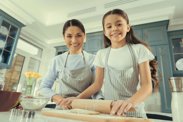 Girls time. Smiling loving nice family making bakery together standing on cozy kitchen