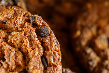 Chocolate chip cookies on rustic dark black background. Stacked chocolate chip cookies on brown napkin. Symbolic image with place for text. Freshly baked. tasty snack. Selective focus. Close up.