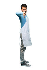 Fototapeta premium A full-length shot of a Man wearing an apron showing thumb down sign with negative expression on isolated background