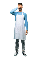 Naklejka premium A full-length shot of a Man wearing an apron covering eyes by hands. Do not want to see something on isolated background