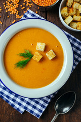 Lentil soup, white plate, blue checkered napkin, wooden background, bean, home cooking