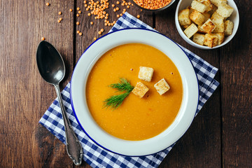 Lentil soup, white plate, blue checkered napkin, wooden background, bean, home cooking