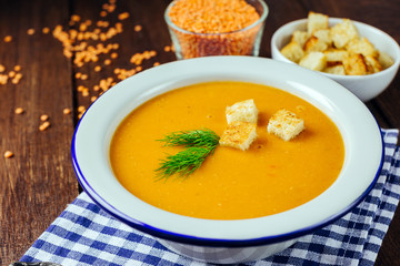 Lentil soup, white plate, blue checkered napkin, wooden background, bean, home cooking