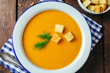 Lentil soup, white plate, blue checkered napkin, wooden background, bean, home cooking