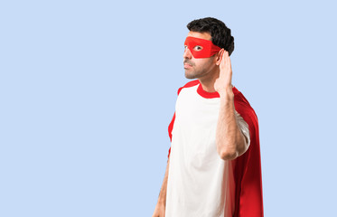 Superhero man with mask and red cape listening to something by putting hand on the ear on isolated...