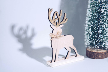 Christmas wooden tree with reindeer over light blue background.