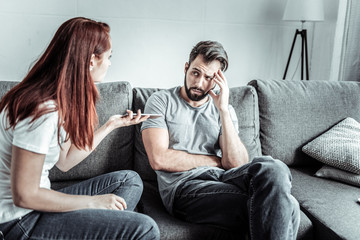 Family quarrel. Profile photo of red haired female that turning head while talking to her man and actively gesticulating