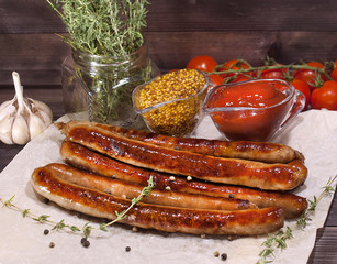 Fried long Bavarian sausages, mustard and ketchup on a wooden table. Delicious food for gourmets, lovers of sausages and beer.