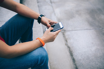 Woman using phone sit on city stairs