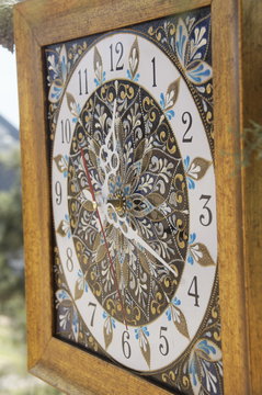 brown square hand-painted watch with contour acrylic paints in the technique point to point, with a geometric pattern in the form of a mandala, black numerals and white arrows