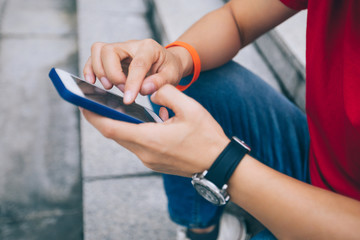 Woman using phone sit on city stairs