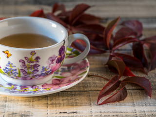 Cup of tea with autumn leaves