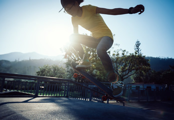 Skateboarder doing ollie at skatepark ramp