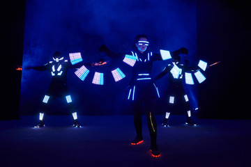 Laser show performance, dancers in led suits with LED lamp, very beautiful night club performance, party