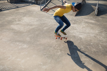 Skateboarder doing ollie at skatepark