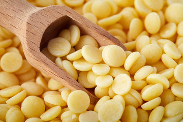 Organic cacao butter buttons (wafers) in wooden scoop