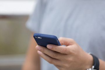 Hands using martphone in modern city