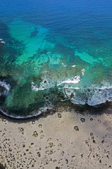 Fototapeta na wymiar Vista aerea della Spiral Caleta, spiaggia della spirale, sassi sul terreno che formano una spirale. Orzola, Lanzarote, Isole Canarie, Spagna. Africa. Coste frastagliate e mare cristallino