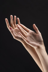 Fototapeta premium Closeup of beautiful woman hands with red manicure on the nails. Cream for palms, manicure and beauty treatment. Elegant and graceful arms with slender graceful fingers.