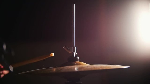 Dashing girl drummer with black hair at garage - rock band
