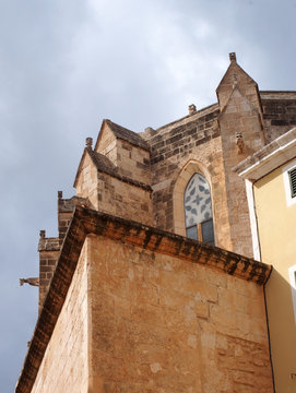 detail corner view of santa maria cathedral in la ciutadella in menorca looking upwards with blue summer sky