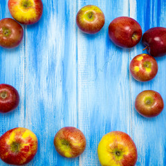 Apples on a blue wooden background. Red and yellow farm apples.