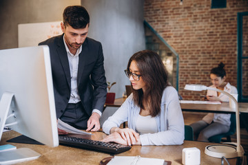 Working on creative project together. Two confident business people in casual wear sitting together at the table and discussing something. startup