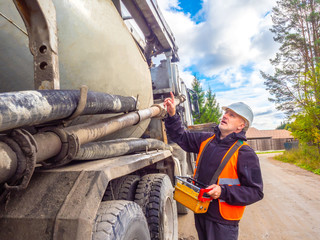 Cement truck. A man operates a cement truck. Cement delivery. Remote control cement supply....