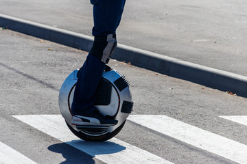 Electric unicycle. Man rides on mono wheel on zebra crossing © olyasolodenko