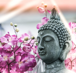 Buddha statue. background blurred flowers