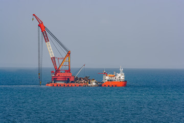 Grab Dredger - revolving crane, fitted with a grab, placed on a hopper vessel or pontoon. Singapore Strait.