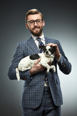 A man in a business suit with a chihuahua.