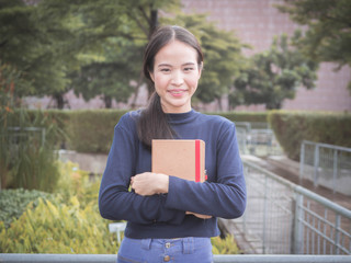 beautiful young Asia woman with reading book at outdoor garden.