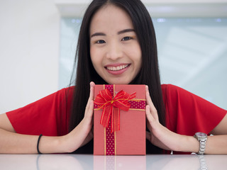 Portrait of a young woman with a red giftbox