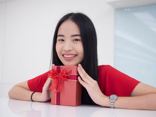 Portrait of a young woman with a red giftbox