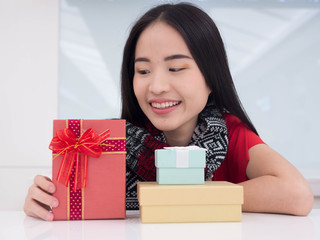 Portrait of a young woman with a red giftbox