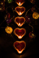 Beautiful diwali diyas at night with flowers, lighting series and gifts, moody background