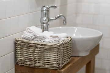 Basket with towels in the bathroom next to the tap