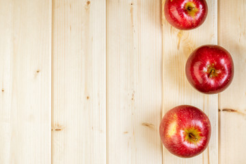 Minimal style, red apples on wooden background with copyspace, autumn, seasonal organic farm food and harvest concept