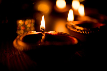 Beautiful diwali diyas at night with flowers, lighting series and gifts, moody background