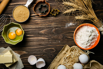 Baking concept - baking ingredients butter, flour, sugar, eggs on rustic wood background, top view