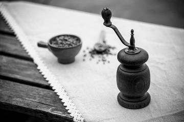 vintage pepper mill and peppercorns on wooden background