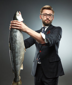 A man in a business suit with fresh salmon i