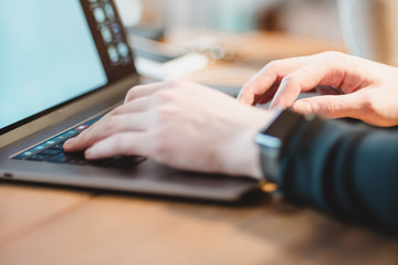 Young male working on a computer with his phone nearby