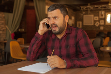 Shocked businessman talking on the phone