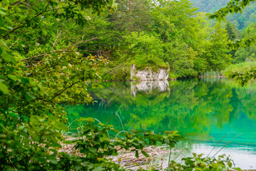 PLITVICE NATIONAL PARK, CROATIA - JUNE 8, 2018: Tourist group by the lake in the Plitvice Lakes National Park.