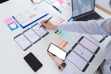 Creative designer hands sketching of screens for mobile responsive website development with UI/UX....