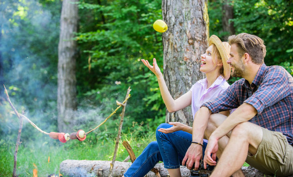 Pleasant smell of roasted food makes picnic atmosphere perfect. Picnic roasting food over fire. Family enjoy weekend in nature. Couple in love relaxing sit on log having snacks. Idyllic picnic date