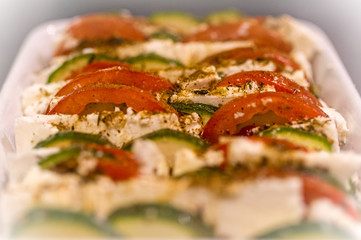 Closeup of casserole with tomate, zucchini and feta cheese